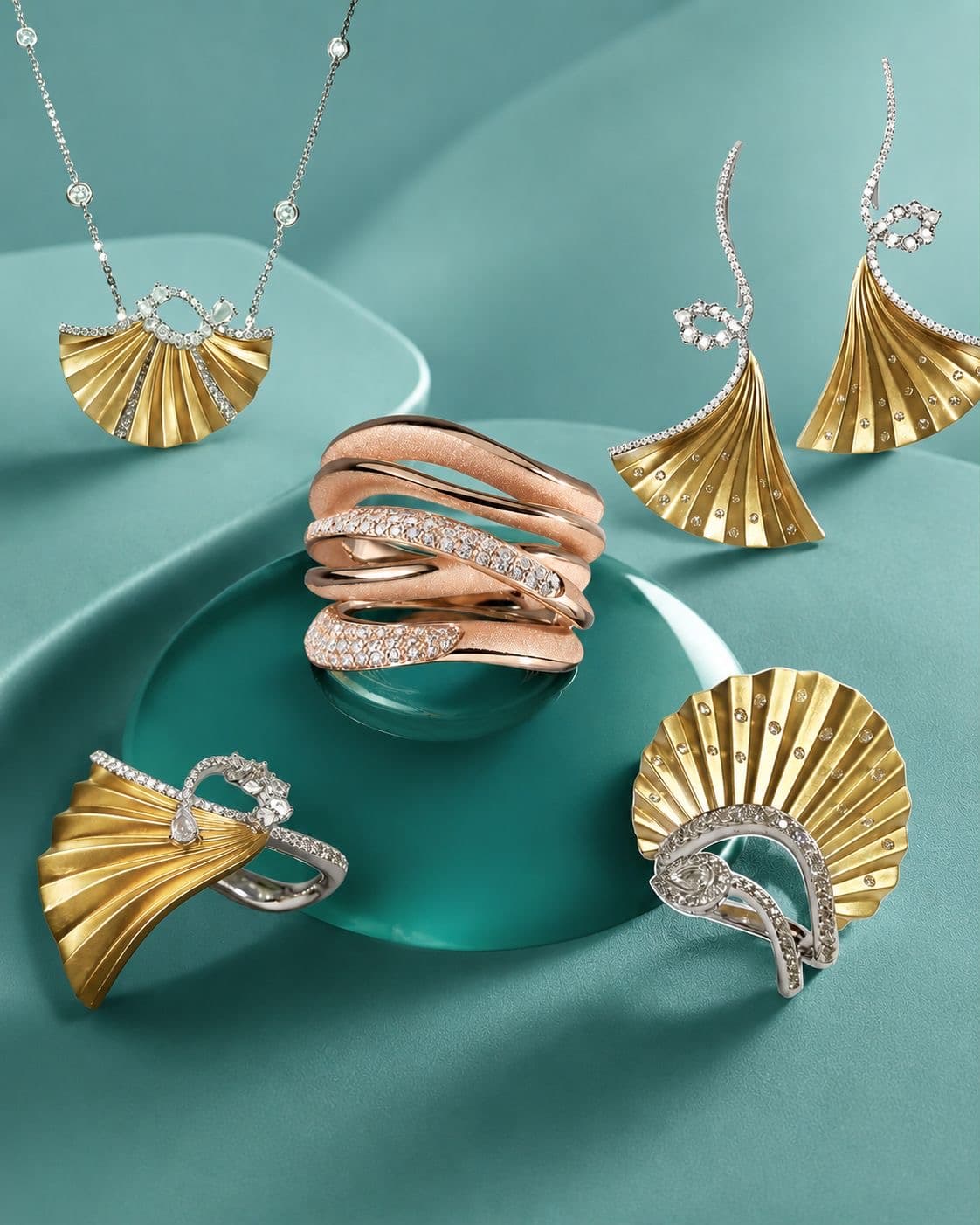 Pleated gold fan jewellery and a rose-gold pavé ring styled on a teal still-life set